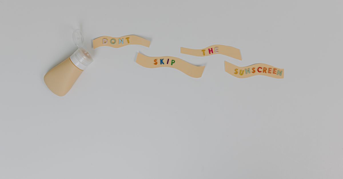 Sunscreen bottle and creative text 'Don't Skip the Sunscreen' on white background, promoting skincare and cancer prevention.